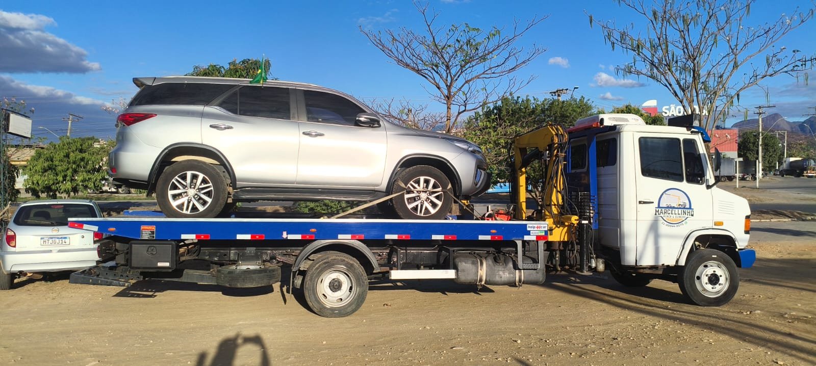 SUV Toyota SW4 prata carregado na plataforma do caminhão.